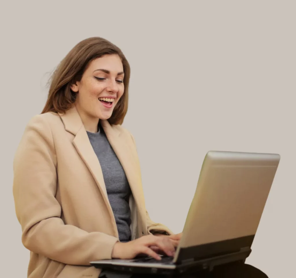 Lächelnde Frau mit stimmiger Website vor Laptop
